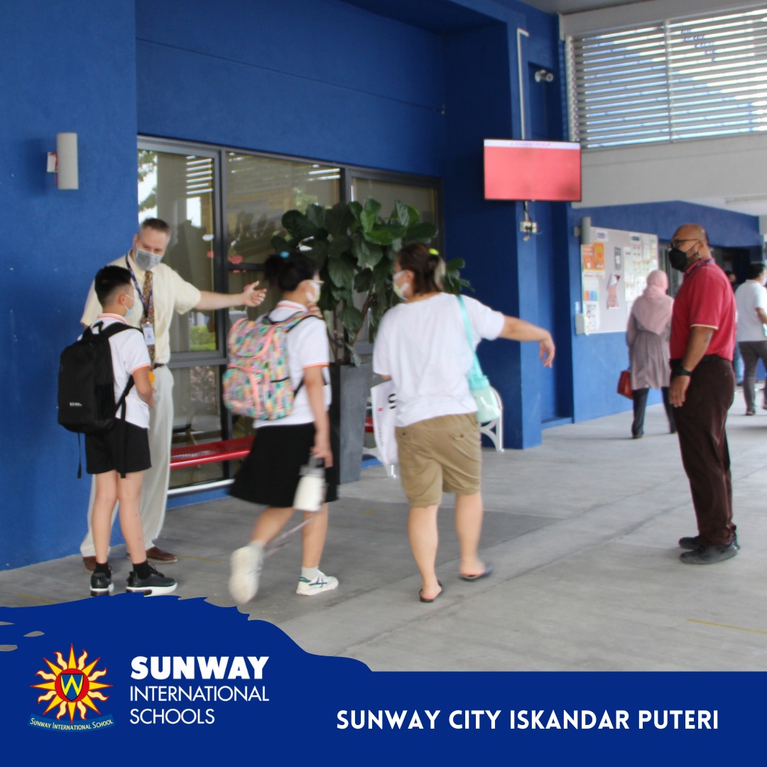 Teachers guide new students to classroom.